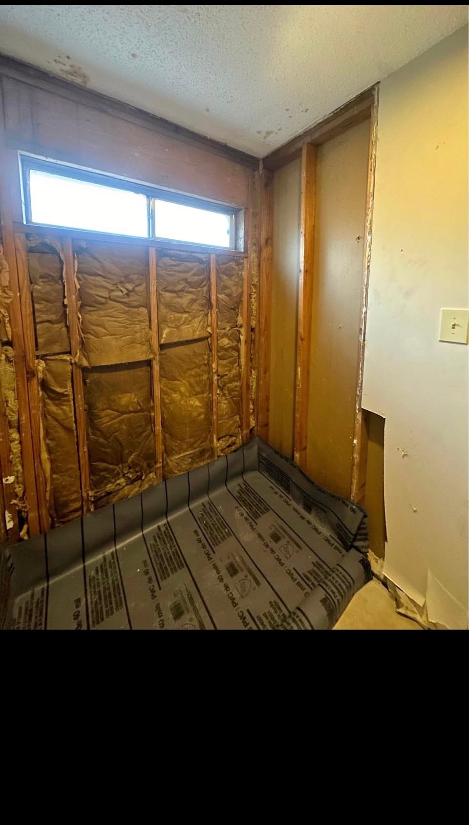 Bathroom demolition gutted to the studs with new shower pan liner ready for rough-in