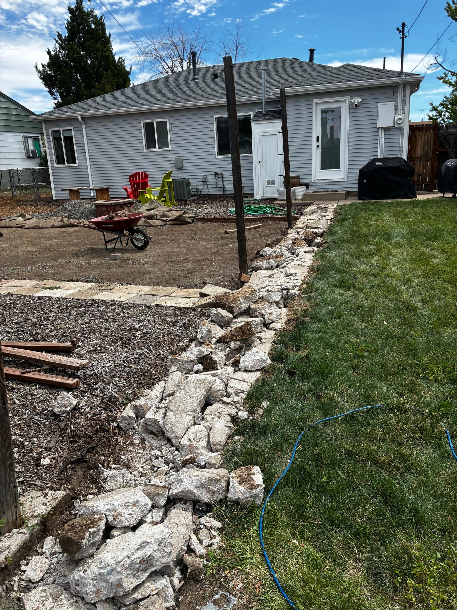 Pile of broken concrete and scrap wood staged on a lawn for demolition debris removal